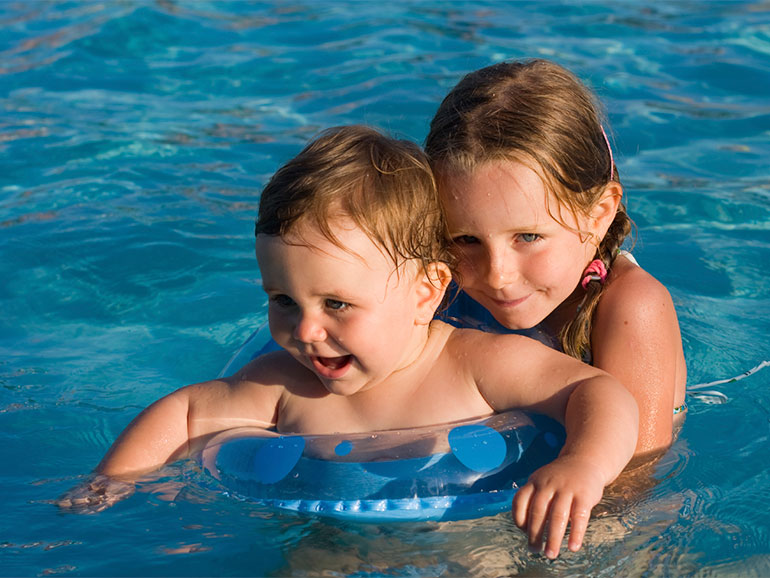niños nadando para prevenir accidentes en piscinas